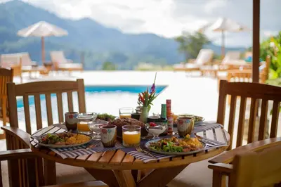 a table with plates of food and drinks on it at Nature's Edge Boutique Hotel in Uvita