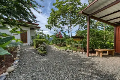 a garden with a bench next to a house at Nature's Edge Boutique Hotel in Uvita
