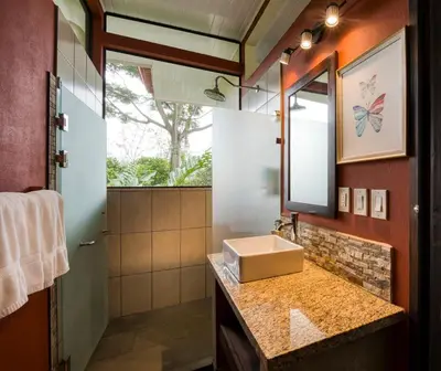 a bathroom with a sink and a mirror at Nature's Edge Boutique Hotel in Uvita