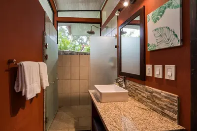 a bathroom with a sink and a mirror at Nature's Edge Boutique Hotel in Uvita