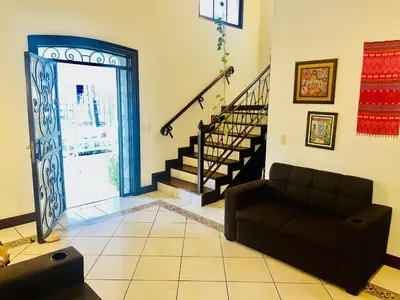 a living room with a couch and a staircase at Ester`s Place in Escazu