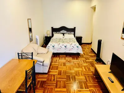 a bedroom with a bed and a wooden floor at Ester`s Place in Escazu
