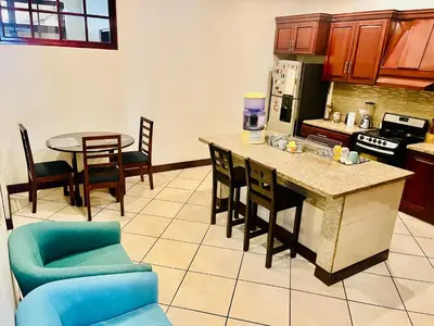 a kitchen with a counter and a table and chairs at Ester`s Place in Escazu