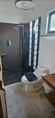 a bathroom with a shower with a toilet and a glass shower at Buddha Retreat Hotel in San Juanillo