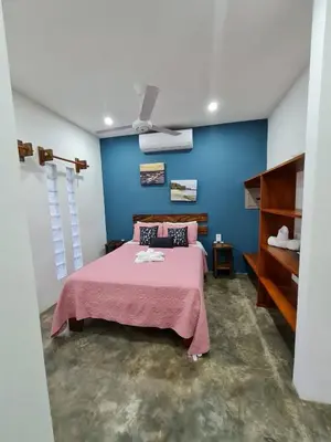 a bedroom with a bed and a blue wall at Buddha Retreat Hotel in San Juanillo