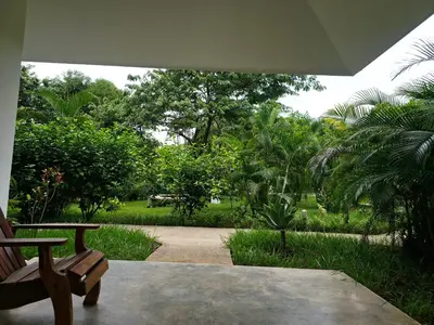 a patio with a bench and a garden with trees at Buddha Retreat Hotel in San Juanillo