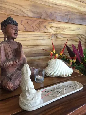 a statue sitting on a table next to a glass at Buddha Retreat Hotel in San Juanillo