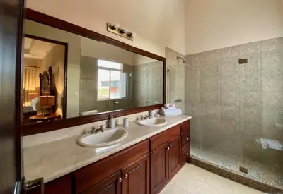 a bathroom with two sinks and a large mirror at Palm Coast Luxury Rentals in Esterillos Este