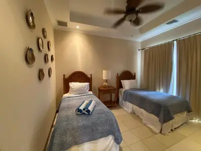 a bedroom with two beds and a ceiling fan at Palm Coast Luxury Rentals in Esterillos Este
