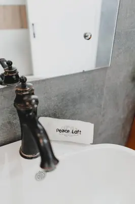a bathroom sink with a faucet and a sign that reads peace left at Peace Lofts and Apartments in Santa Teresa Beach