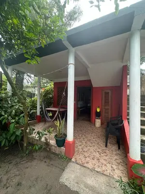 a front porch of a house with a bike on it at Hotel Don Quichotte in Tortuguero