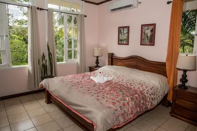 a bedroom with a bed with a red comforter at Villas las Palmas in Fortuna