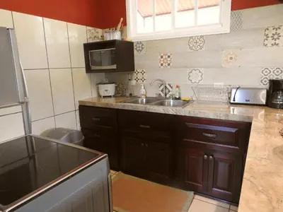 a kitchen with a sink and a microwave at Villas las Palmas in Fortuna
