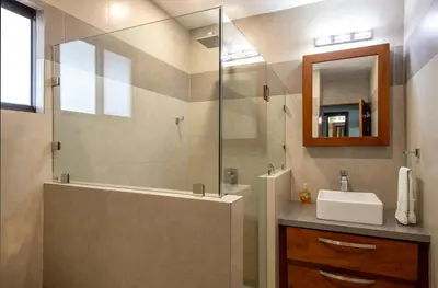a bathroom with a shower and a sink and a mirror at Newly Remodeled Beachfront Condo, Ground-Floor Terrace & Direct Access to Playa Flamingo in Playa Flamingo