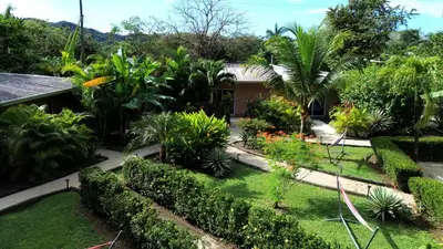 a garden in front of a house at Tee-K Lodge Tamarindo in Tamarindo