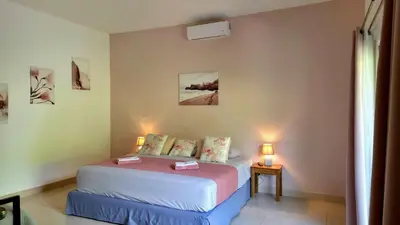 a bedroom with a bed in a room with two lamps at Tee-K Lodge Tamarindo in Tamarindo
