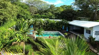 an aerial view of a house with a swimming pool and trees at Tee-K Lodge Tamarindo in Tamarindo