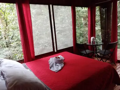 a bed in a room with a red blanket at The Green Tree Lodge in Monteverde Costa Rica