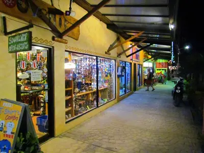 a building with a bunch of shops on a street at Tamarindo Condo 206 Matapalo in Tamarindo