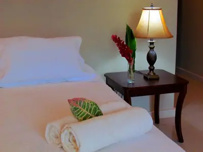 a bedroom with a bed with a table with a lamp at Tamarindo Condo 206 Matapalo in Tamarindo
