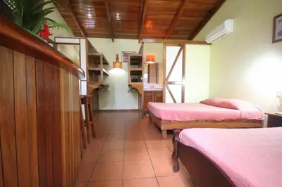a room with two beds with pink sheets in it at Nosara Paradise Rentals in Nosara
