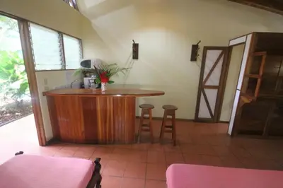 a bar in the corner of a room with two stools at Nosara Paradise Rentals in Nosara