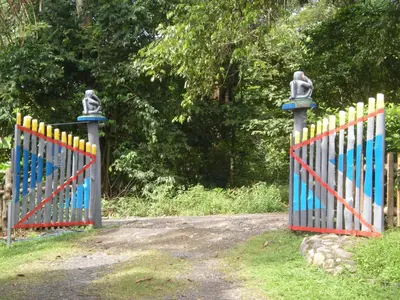a gate with a colorful fence in a field at Lodge El Barco in Esterillos