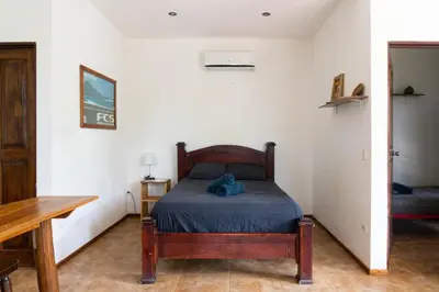 a bedroom with a bed and a wooden table at Chicama : Burnt Toast Surfcamp in Nosara
