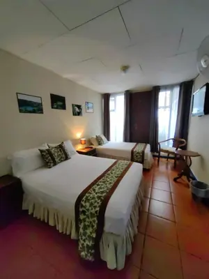 a hotel room with two beds in a room at Hotel Casa Tago in Alajuela City