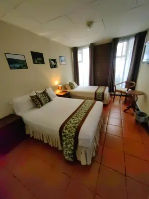 a hotel room with two beds in a room at Hotel Casa Tago in Alajuela City