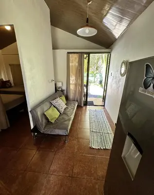 a living room with a couch in the middle of a room at Casa Morpho Uvita Guesthouse in Uvita