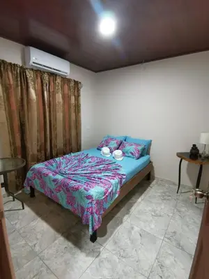 a bedroom with a bed with a blue comforter at Hotel Sueños de María in Uvita