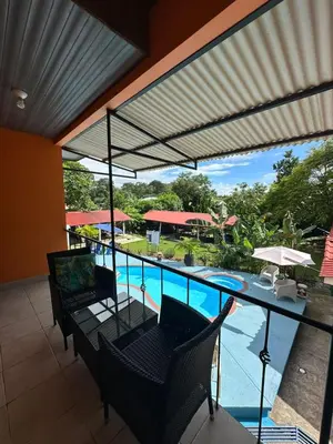 a patio with a table and chairs and a swimming pool at Hotel Sueños de María in Uvita