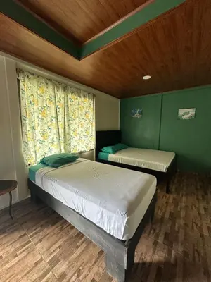 a bedroom with two beds and a window at Hotel Sueños de María in Uvita