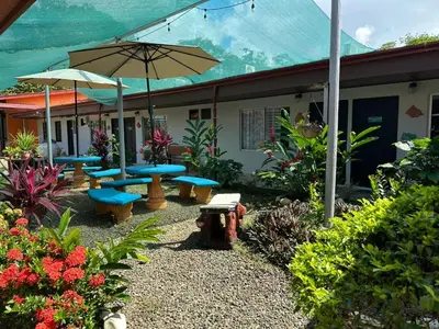 a patio with blue benches and an umbrella at Hotel Sueños de María in Uvita