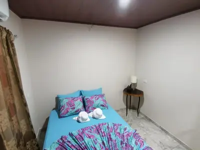a bedroom with a blue bed with shoes on it at Hotel Sueños de María in Uvita