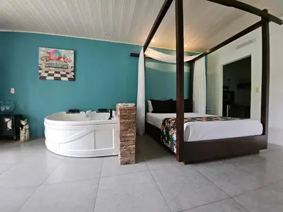 a bedroom with a bed and a bath tub next to a bed gmaxwell gmaxwell gmaxwell at Yellow Tree Suites in Fortuna