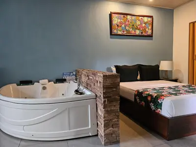 a room with a bath tub next to a bed at Yellow Tree Suites in Fortuna