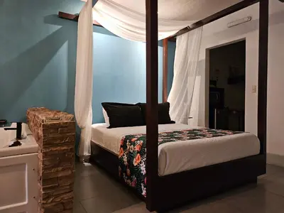 a bedroom with a bed with a canopy at Yellow Tree Suites in Fortuna