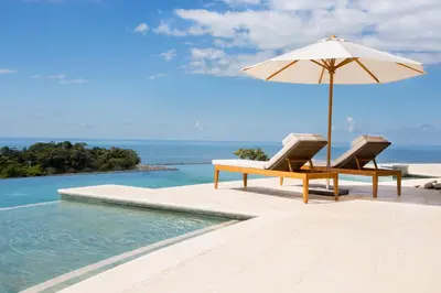 a pool with a table and an umbrella and chairs at Hotel Three Sixty - Adults Only in Ojochal