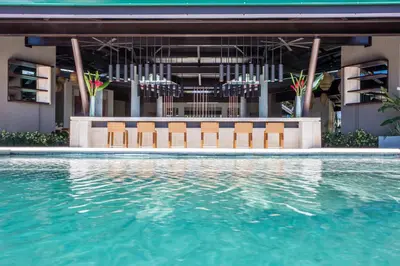 a swimming pool with chairs and a building at Hotel Three Sixty - Adults Only in Ojochal