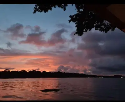 a sunset over a body of water with clouds at Casa Marbella in Tortuguero