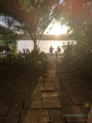 a group of people sitting on benches near the water at Casa Marbella in Tortuguero