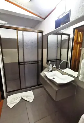a bathroom with a sink and a large mirror at Casa Marbella in Tortuguero