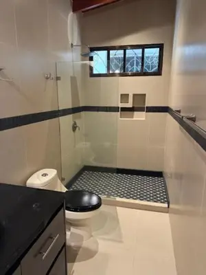 a bathroom with a shower with a toilet and a window at Villas Lambeau 3 Ocean View - 2BR 3 BA in Uvita