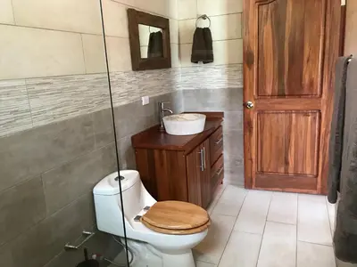 a bathroom with a toilet and a sink at Villas Lambeau 3 Ocean View - 2BR 3 BA in Uvita
