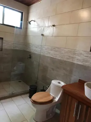 a bathroom with a toilet and a shower at Villas Lambeau 3 Ocean View - 2BR 3 BA in Uvita