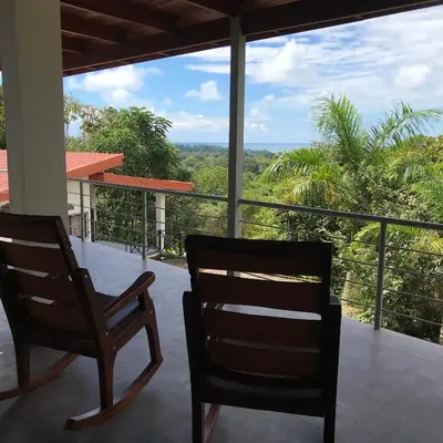 two chairs on a porch with a view of the jungle at Villas Lambeau 3 Ocean View - 2BR 3 BA in Uvita