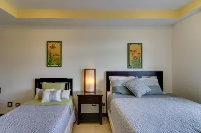 a bedroom with two beds and a table with a lamp at Naxos 15 in Tamarindo