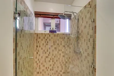 a bathroom with a shower with a glass door at Naxos 15 in Tamarindo